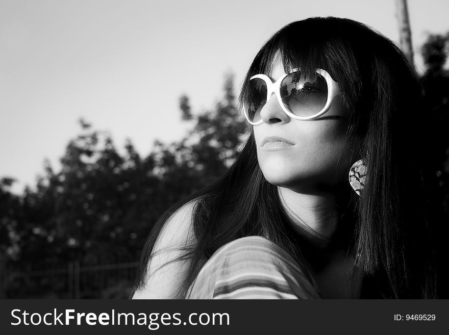Young modern girl in black-white watch in sun with sunglases