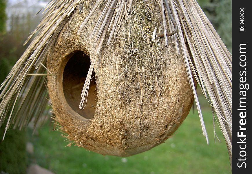 Round bird box with straw shelter in garden. Round bird box with straw shelter in garden