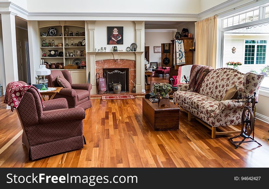 Attractive sitting room (lounge) furnished with beige patterned sofa and purple arm chairs (with wings), polished wooden floor and fireplace with safety screen. Attractive sitting room (lounge) furnished with beige patterned sofa and purple arm chairs (with wings), polished wooden floor and fireplace with safety screen.