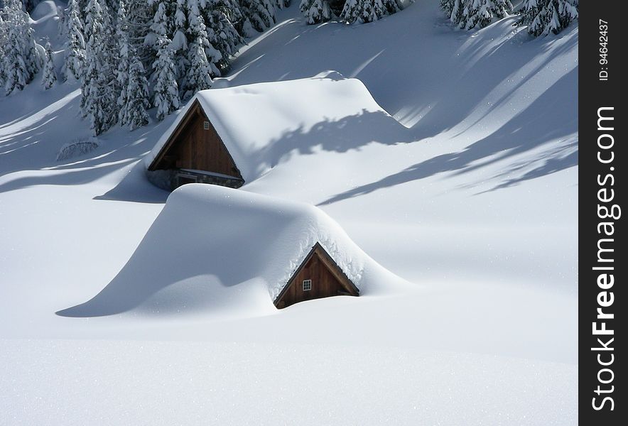 Wooden cabins covered in snow.
