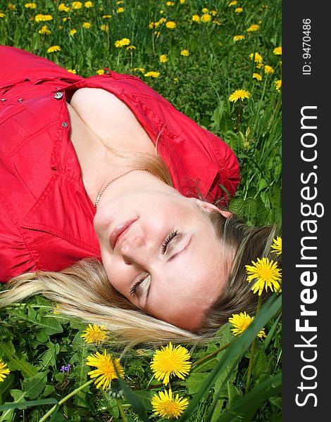 Young girl lying in dandelion meadow