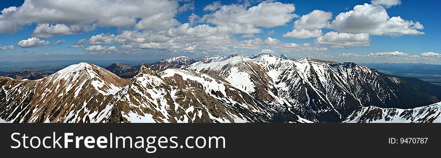 Panorama of mountains in spring with cloudy blue sky. Panorama of mountains in spring with cloudy blue sky
