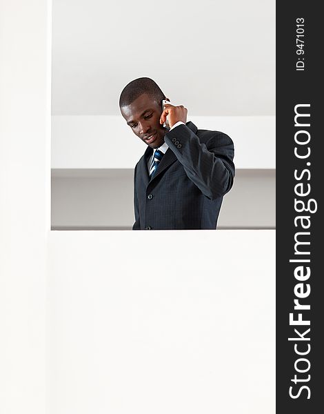 Young adult afro-american businessman talking on the phone indoors. Copy space