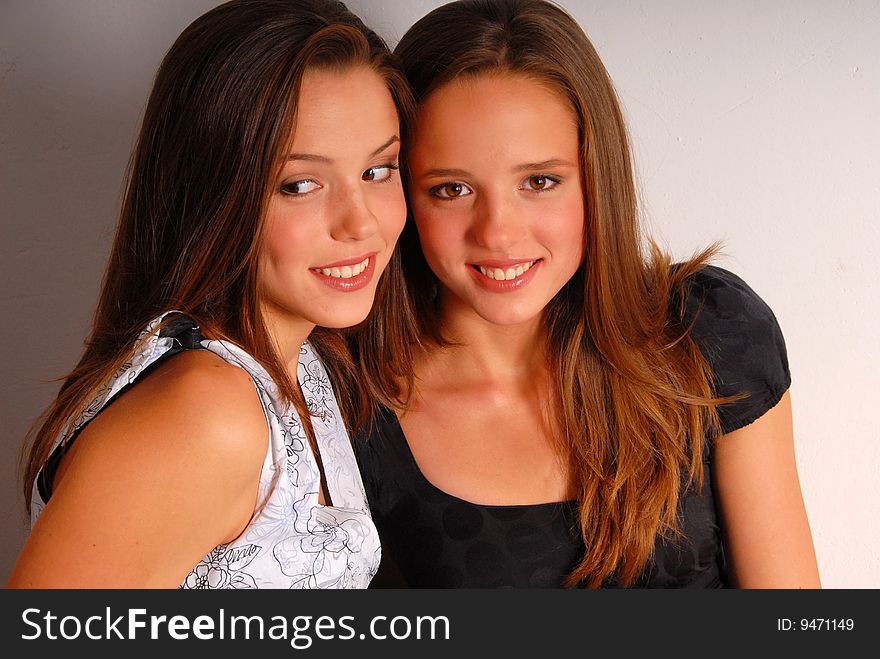 Close-up portrait of two beautiful attractive long-haired smiling girls. Close-up portrait of two beautiful attractive long-haired smiling girls
