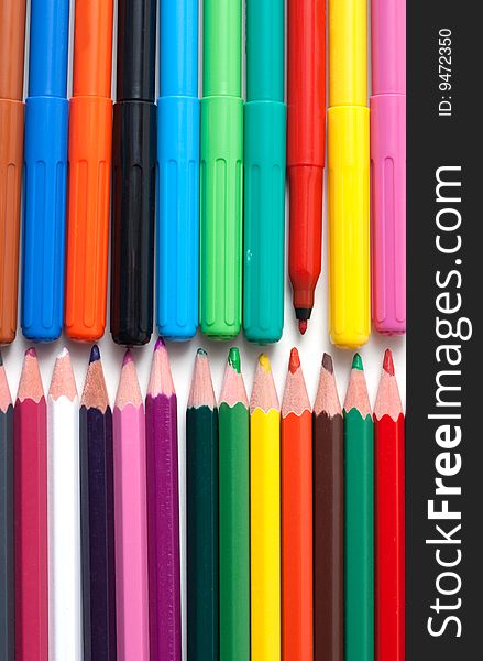 Crayons and soft-tip pens to rest upon white background. Crayons and soft-tip pens to rest upon white background