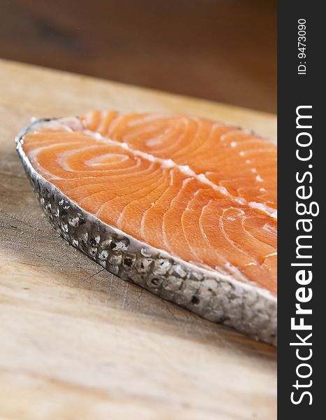 Raw salmon fillet on an old wooden kitchen board