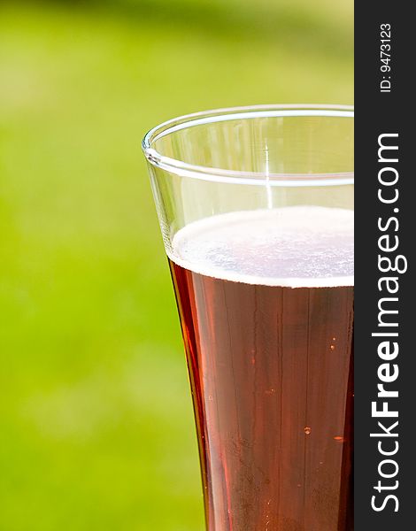 Glass beer on green background
