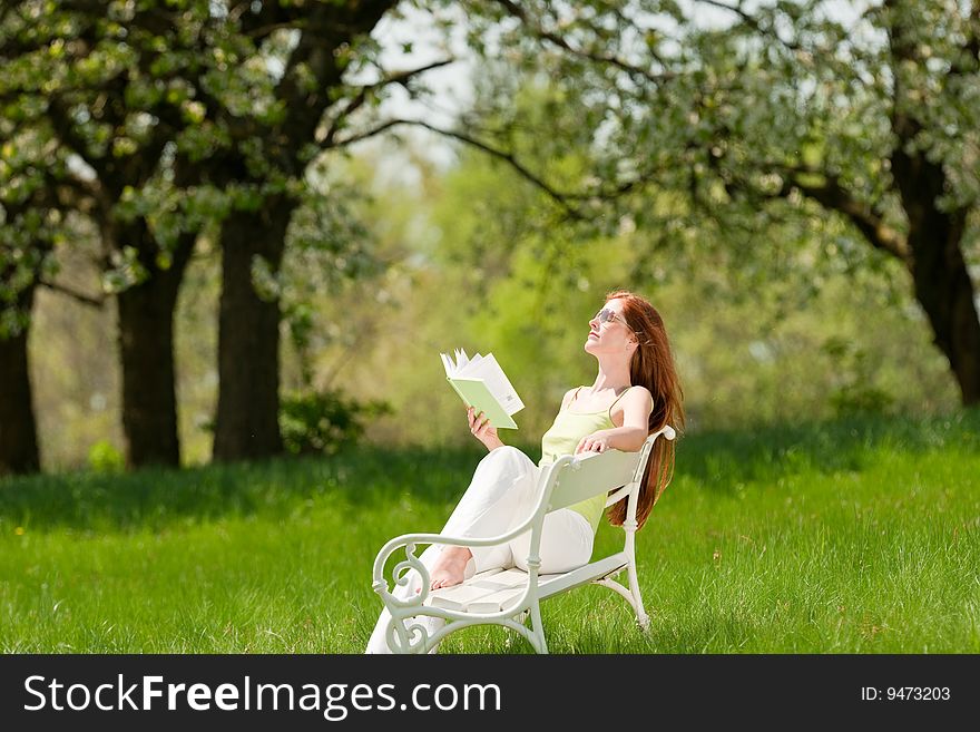 Woman relax under blossom tree in summer