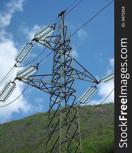 A pylon with a bright blue sky and a beautiful mountain as background. A pylon with a bright blue sky and a beautiful mountain as background