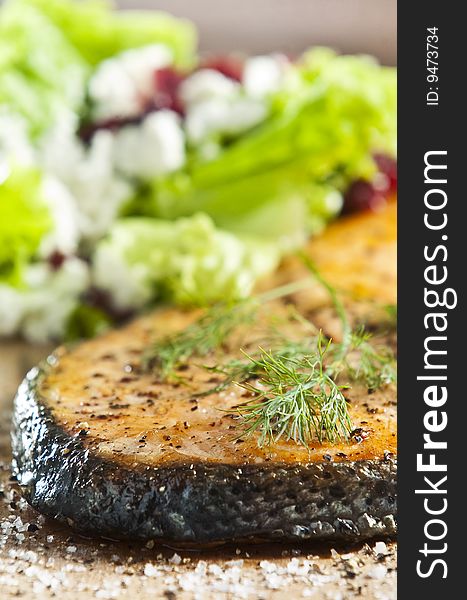 Grilled salmon on old wood board garnished with dill. Grilled salmon on old wood board garnished with dill