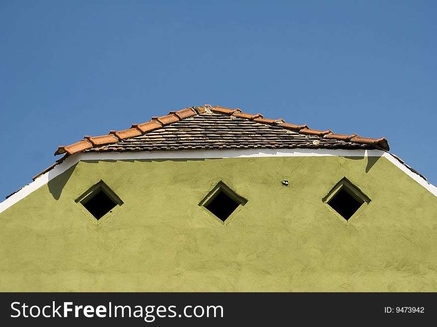 A green old house roof on a sunny day