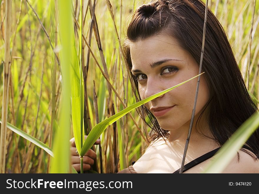 Young woman smiling in a field of grass. Young woman smiling in a field of grass