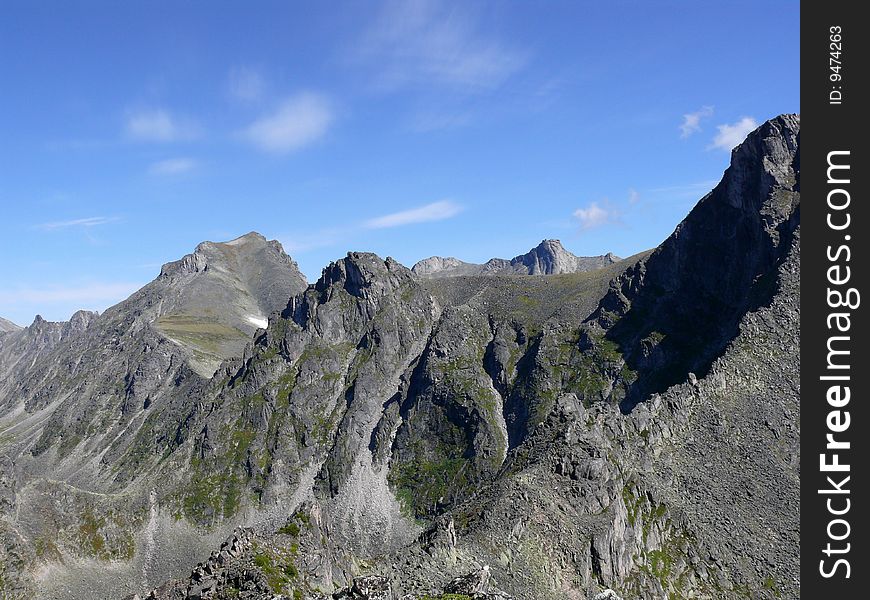 Mountains against the blue sky and easy clouds