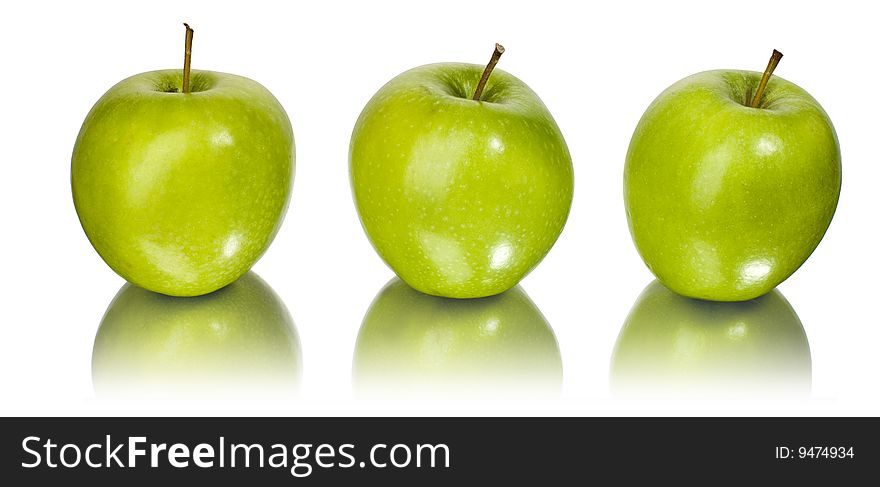 Three green apples on a mirror with white background