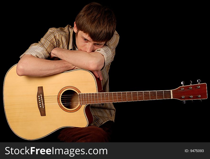 Young musician playing classic guitar isolated on black. Young musician playing classic guitar isolated on black