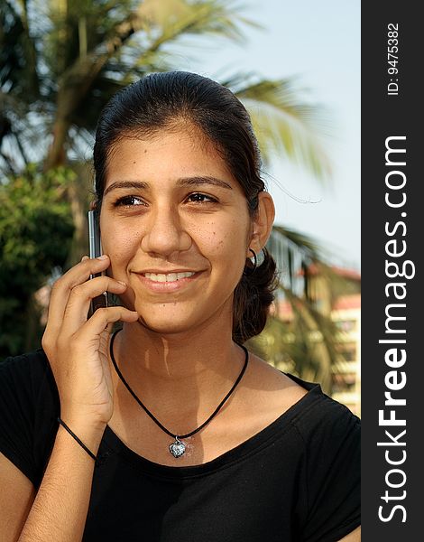 A smart Indian girl receiving a happy news over the phone. A smart Indian girl receiving a happy news over the phone.