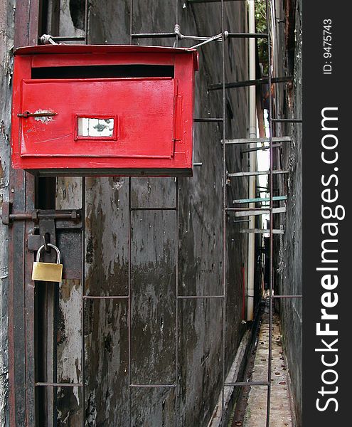 A metal mail box and a lock hanging on metal gate. A metal mail box and a lock hanging on metal gate.