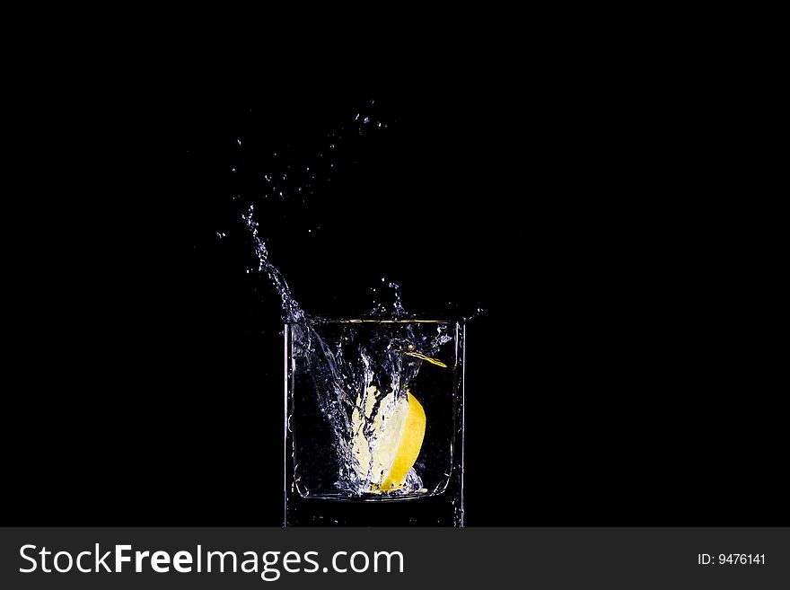 Citron flows into glass of water. Citron flows into glass of water