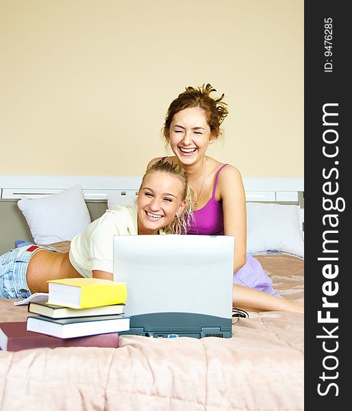 Portrait of two happy laughing girls preparing for the exam at home. Portrait of two happy laughing girls preparing for the exam at home