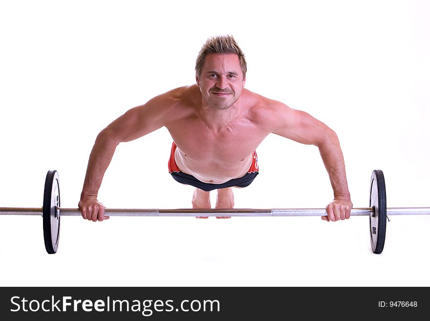 Man making pushups on barbell. Man making pushups on barbell