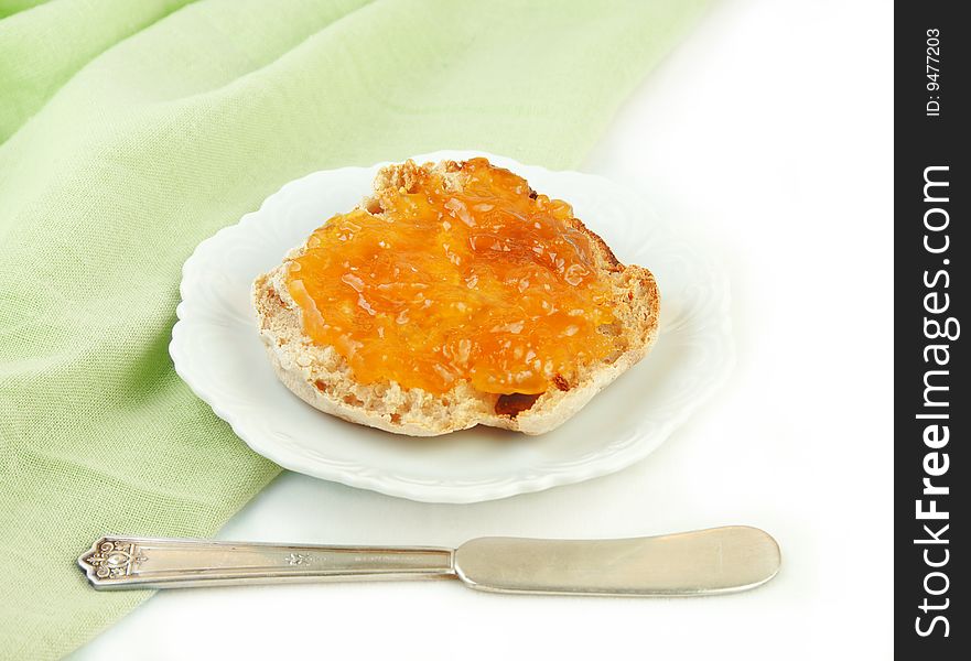 English muffin with marmalade on green and white background. English muffin with marmalade on green and white background.