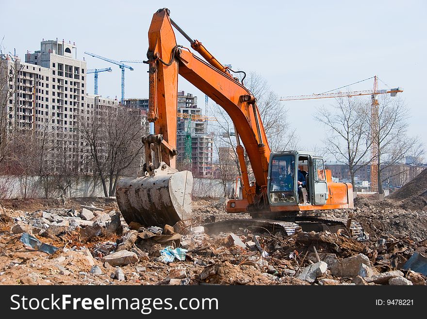 Excavator works in a construction site. Excavator works in a construction site