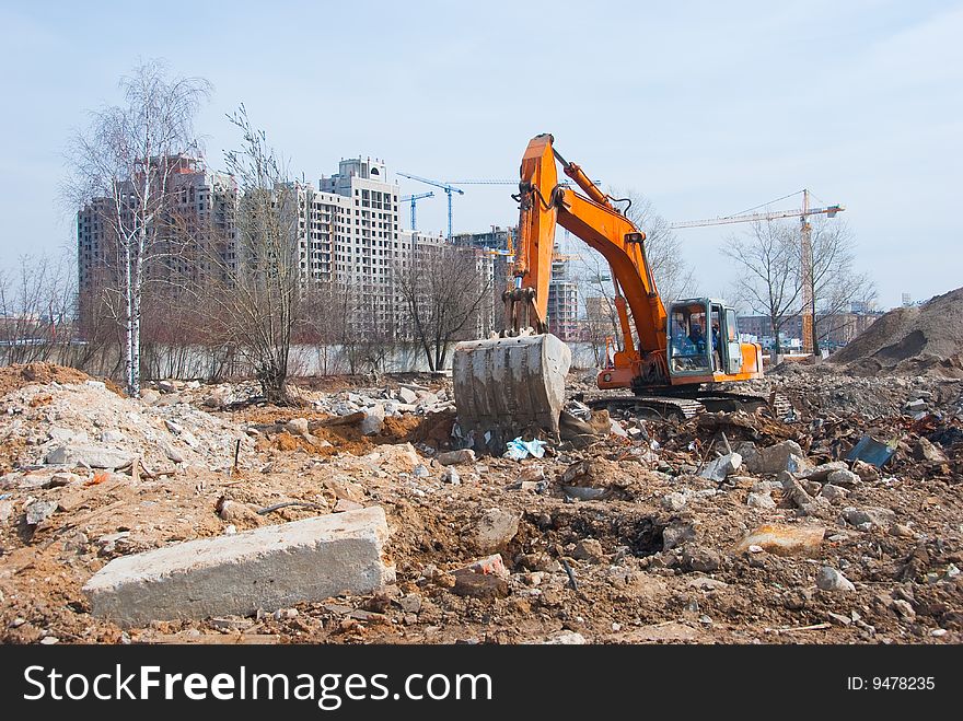 Excavator works in a construction site. Excavator works in a construction site