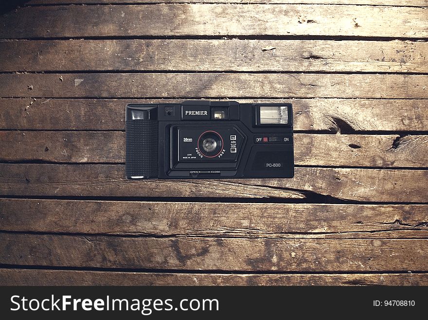 Classic retro style camera on wooden background.
