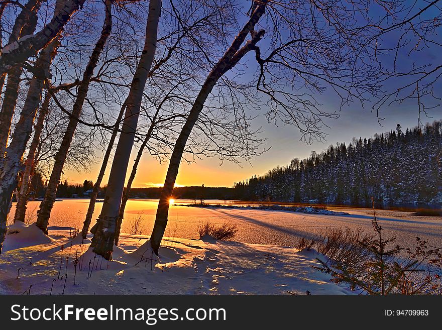 A winter morning sunrise over snowy fields or lakes.