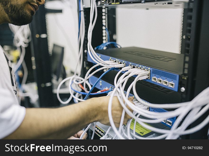 Man Installing Cables In Server Rack