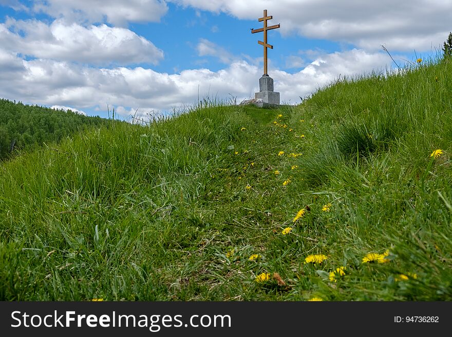 The cross on the mountain, the grass is green and the path leading to the cross