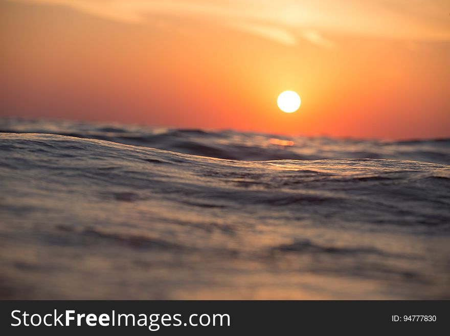 Sunset in orange skies over ocean waves. Sunset in orange skies over ocean waves.