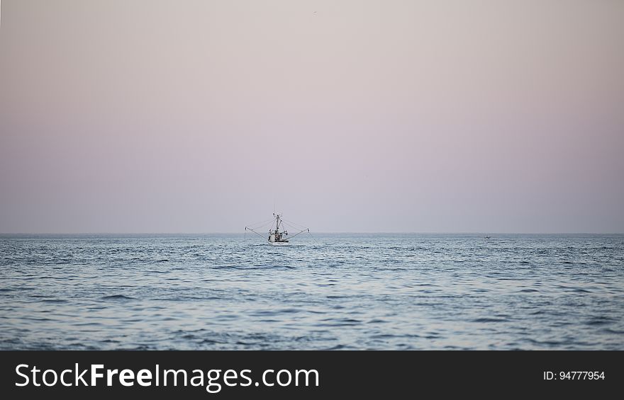 Fishing Boat On Water At Sunset