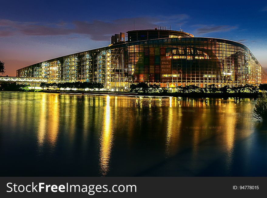Illuminated building on waterfront of Strasbourg, Austria at night reflecting in river. Illuminated building on waterfront of Strasbourg, Austria at night reflecting in river.