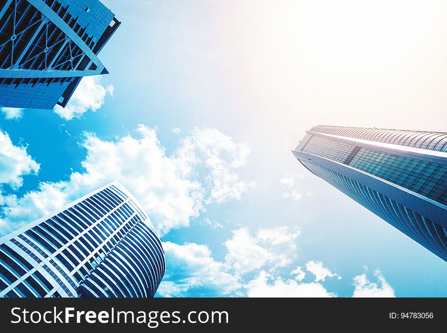 A low angle view between three high rise buildings.