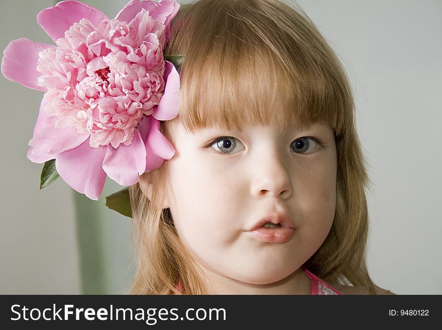 Small girl with the pink flower in her hair. Small girl with the pink flower in her hair