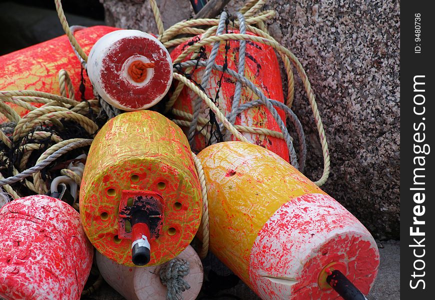 Colorful fishing buoys resting against rocks. Colorful fishing buoys resting against rocks