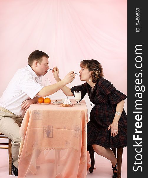 Young couple in love feeding each other with cake