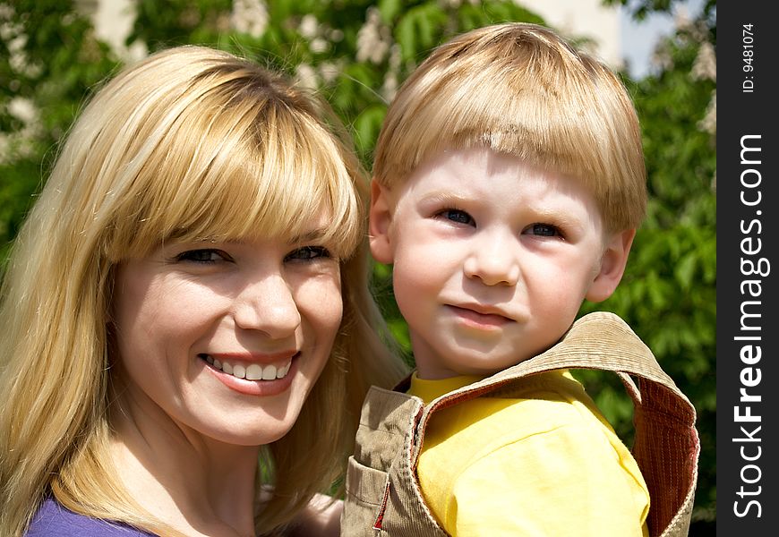 Woman and young boy outdoors embracing and smiling. Woman and young boy outdoors embracing and smiling
