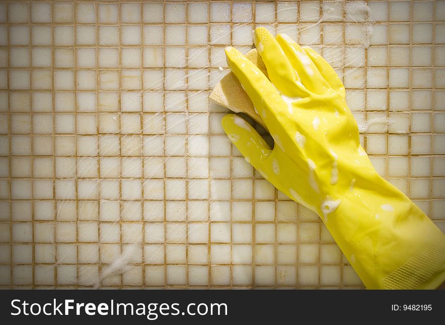 Hand in rubber glove washing the wall. Hand in rubber glove washing the wall