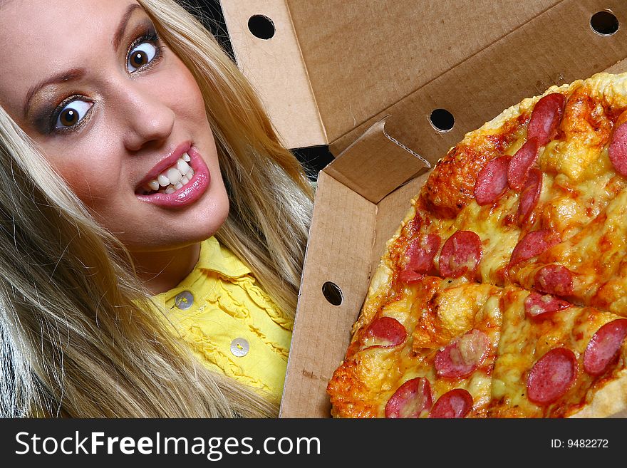 A beautiful young woman eating pizza