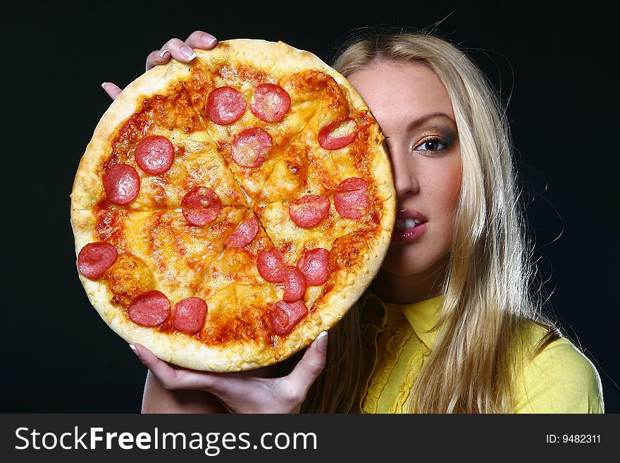 A beautiful young woman eating pizza