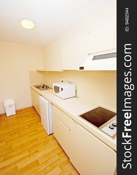 The neatly laid out pantry of a hotel room, comprising of a microwave oven, an electric stove, a sink and a mini refrigerator. The neatly laid out pantry of a hotel room, comprising of a microwave oven, an electric stove, a sink and a mini refrigerator.