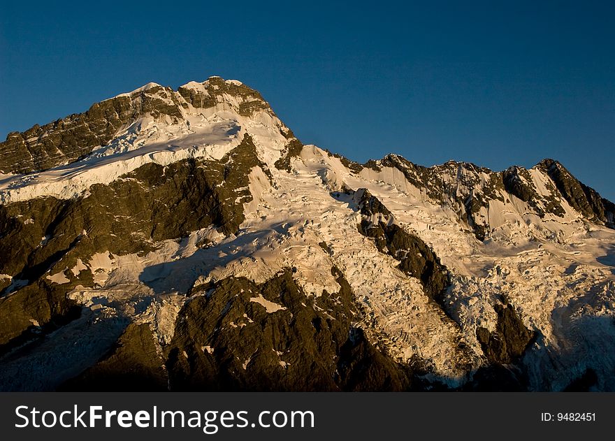 Rugged Mt Sefton on the South Island of New Zealand, close to Aoraki (the highest mountain in NZ).  Ridgeline with ice and snow, at sunset. Rugged Mt Sefton on the South Island of New Zealand, close to Aoraki (the highest mountain in NZ).  Ridgeline with ice and snow, at sunset.