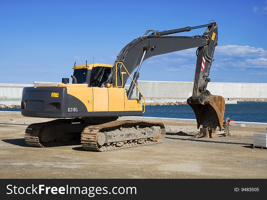 Large bulldozer at construction site near the ocean. Large bulldozer at construction site near the ocean