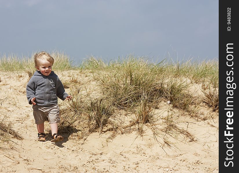 A little boy playing on sand dunes. A little boy playing on sand dunes