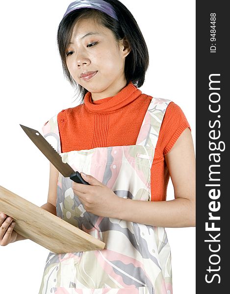 Young Asian girl, preparing food, holding wooden tray and knife. Model wearing cooking apron. Young Asian girl, preparing food, holding wooden tray and knife. Model wearing cooking apron.