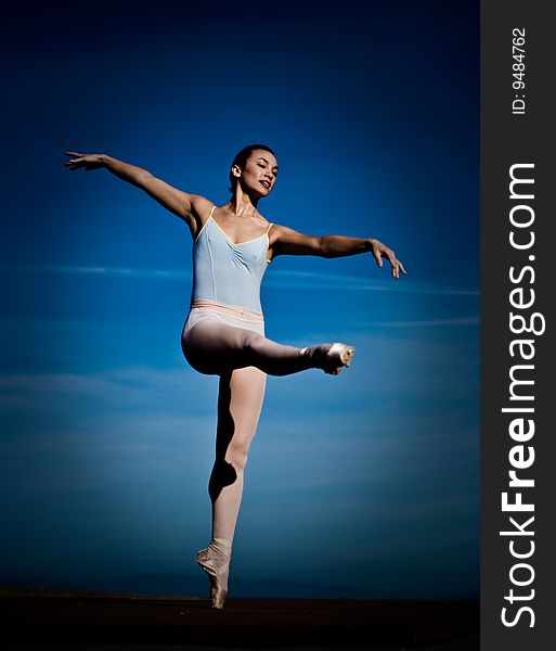 Ballet dancer poses in front of open blue sky. Ballet dancer poses in front of open blue sky