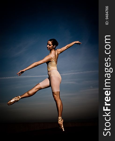 Ballet dancer poses in front of open blue sky. Ballet dancer poses in front of open blue sky