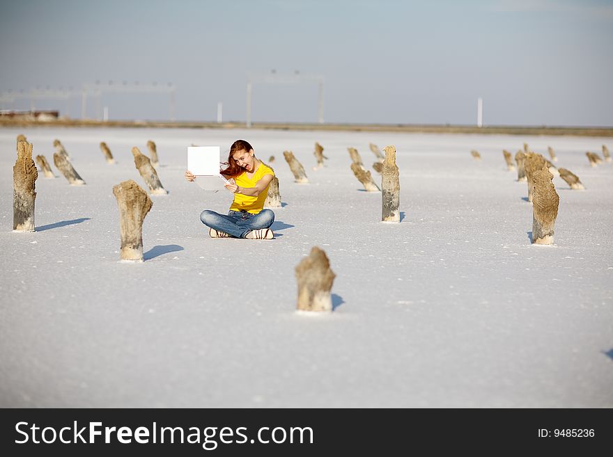 Happy girl with notebook on the sand